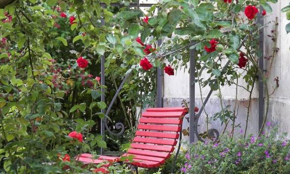 romantische Sitzecke rote Bank und rote Rosen