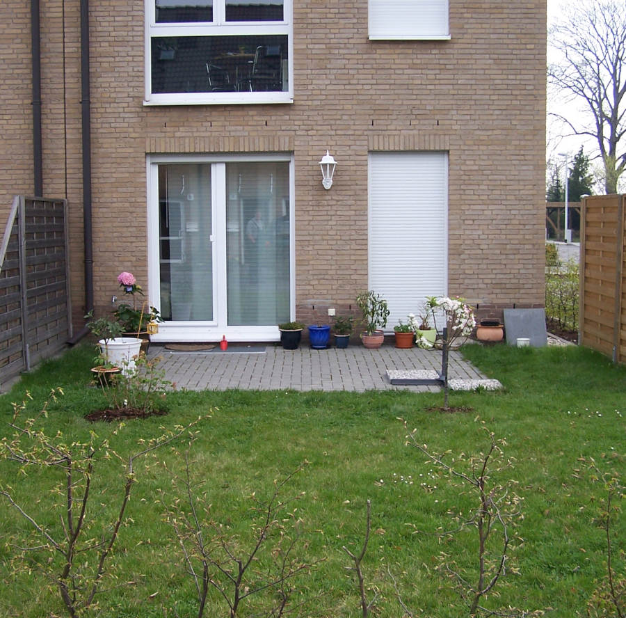 Kleiner Reihenhausgarten mit Rasen und kleiner Terrasse