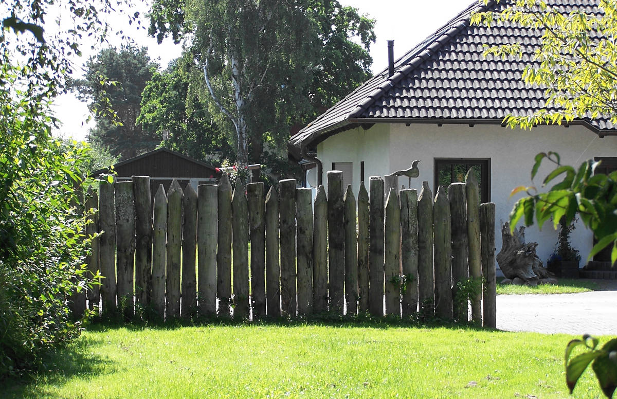 Urige Sichtschutzpalisaden aus Holz am Hausgarten