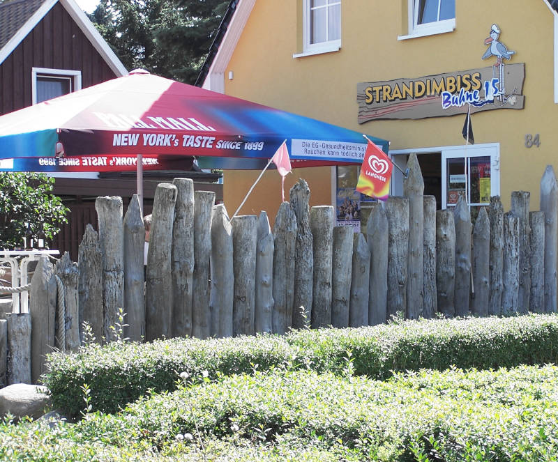 Windschutz aus Holzpalisaden an einem Restaurant